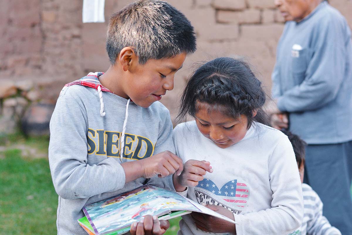 A young boy and a young girl reading together A young boy and a young girl reading together